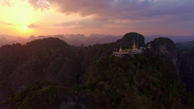 .Aerial view colorful clouds at sunset behind the Golden  Buddha on the mountain peak. .The clouds, illuminated by the setting sun, .create a beautiful and serene atmosphere. Sky texture..
