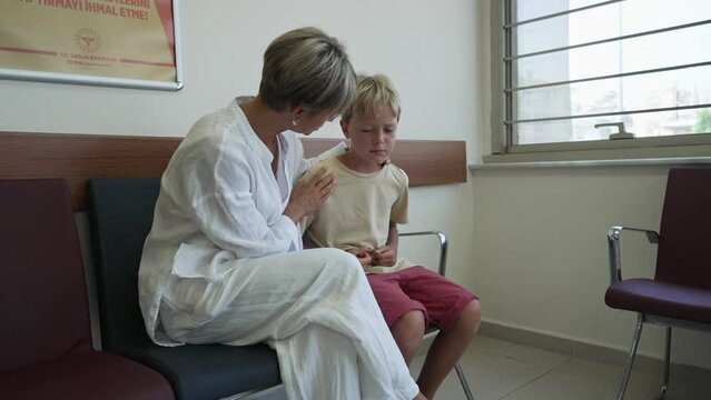 Boy with stomachache in hospital with mom.