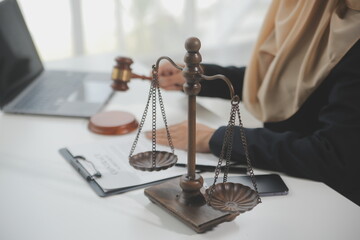 Business and lawyers discussing contract papers with brass scale on desk in office. Law, legal services, advice, justice and law concept picture with film grain effect