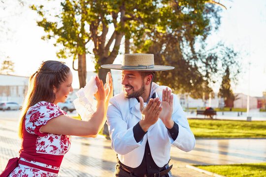 retrato pareja joven vestidos con ropa tradicional huaso aplaudiendo al ritmo del baile de cueca en la plaza
