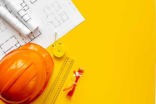 Layout of drawing blueprints for architectural project with construction helmet