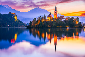 Fototapeta na wymiar Bled, Slovenia - Sunrise with Julian Alps and Church Santa Maria, beautiful Europe.