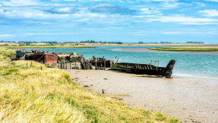 Wrecked Boats in the Oare Creek in Oare near Faversham - Kent with the Isle of Sheppey in the distance