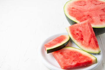 top view of red watermelon slices on plate and white background, horizontal, with copy space