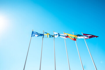 The flags of the Baltic countries and Scandinavia waving in the sky of a beautiful summer day.