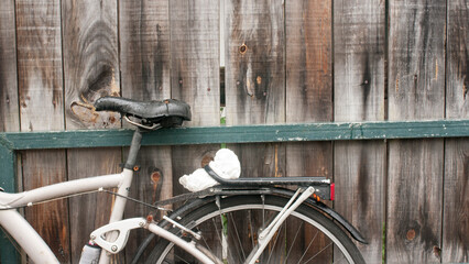 Bicicleta apoyada en pared de tablones de madera