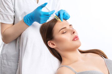 Cosmetologist does anti wrinkle injections of a beautiful woman. Women's cosmetology in the beauty...