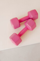 Two pink dumbbells on white