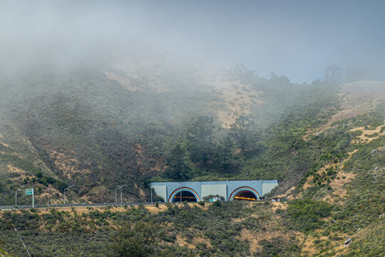 San Francisco, CA, USA - July 12, 2023: South entrance and exit to Robin Williams tunnel across Golden Gate bridge in Marin county. Fog and green hills