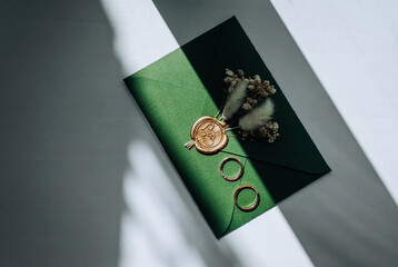 Wedding accessories, details: an envelope with a stamp, gold rings, boutonniere made of reeds and...