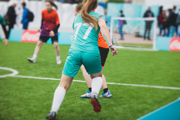 Female football street match outdoor game on an artificial astroturf lawn, girls play soccer game...