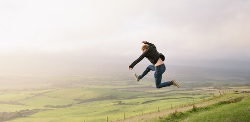 A man jumping on top of a mountain