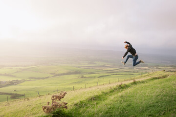 A man jumping on top of a mountain