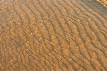 Background texture of sea sand in shallow water.