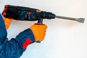 Hands in protective gloves with hammer drill, perforator