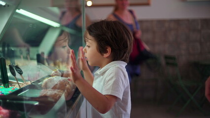 Child Leaning on Ice-Cream Glass Counter, Staring at Flavors, Childhood Concept of salivating Dessert
