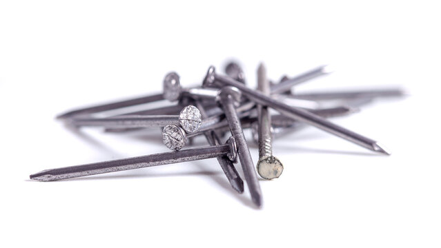 Pile of small grey metal nails isolated on white background. Close-up