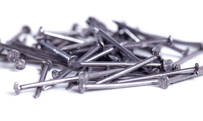Pile of small grey metal nails isolated on white background. Close-up