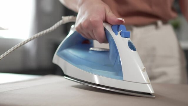 one woman ironing clothes at home hold iron household chores concept
