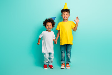 Full body photo of cute two little boys wave palm hold hands birthday party dressed stylish clothes...