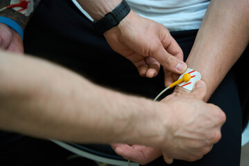 Experienced cardiologist preparing adult person for ECG test © Svitlana