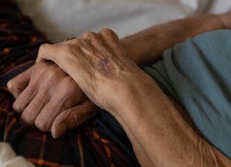 Elderly person with hands crossed