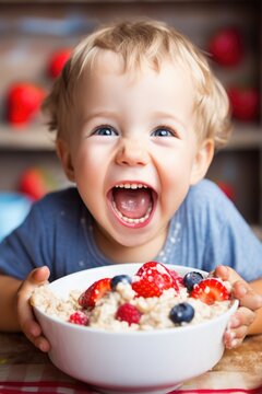 Naklejki Smiling adorable child having breakfast eating oatmeal porridge with berries. 