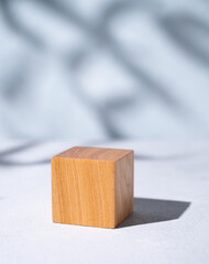 Wooden cube empty for product demonstration or mock-up with shadows on a blue background. Stand for...
