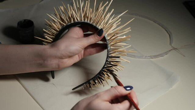 The hands of the master paint a hoop with needles