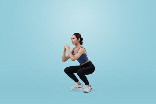 Vigorous energetic woman doing exercise. Young athletic asian woman strength and endurance training session as squat workout routine session. Full body studio shot on isolated background. © Summit Art Creations