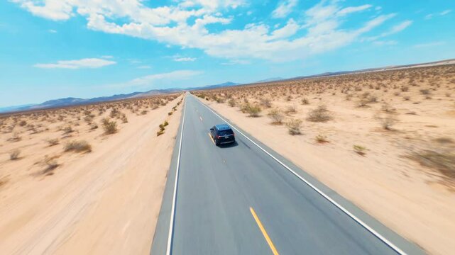 A man walking on a highway in the desert. Aerial FPV Drone footage of man walking in monument valley.  Aerial FPV - A man walks alone on the road. 