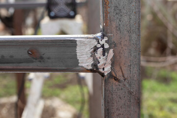 Welding seam on a metal structure made of a profile pipe, cleaned with an emery wheel. Determining the quality of welding