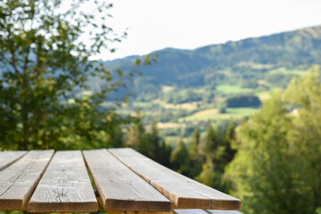 wooden picnic table for outdoor eating with a view of landscape from a garden
