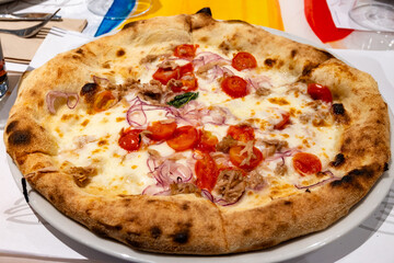 Eating of fresh baked pizza dish in italian pizzeria restaurant