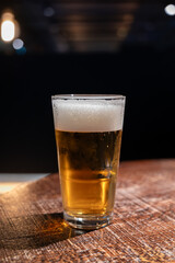 Pint glass of cold fresh british ale and lager beer served in old vintage English pub