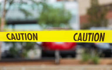 Yellow caution tape on streets symbolizes danger, restriction, and safety measures, warning of hazards or construction sites