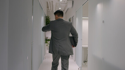 Back view unknown businessman entrepreneur ceo employer hurry run on business meeting with partners in office busy man go in company hallway checking hour on wristwatch late time management lateness