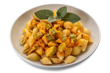 Conchiglie rigate pasta. Macaroni in shape of ridged shell with courgette and tomato sauce with sage leaves in white dish isolated