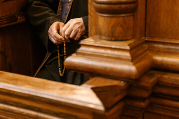 the secret of confession in the Catholic church: Photo of the hands of the priest confessing in the confessional - obrazy, fototapety, plakaty