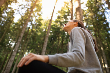 Smiling Young Woman Enjoying Tranquil Morning in Peaceful Nature Forest 	