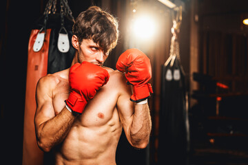 Boxing fighter shirtless posing, caucasian man boxer wearing red glove in defensive guard stance...