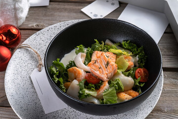 Salmon steak, calamari, shrimp with salad for New Year's table. New Year's decor, beautiful table. Side view, macro