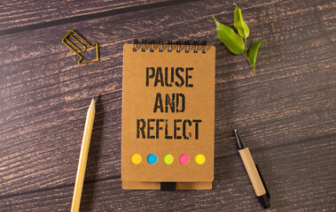 Businessman holding a card with text PAUSE AND REFLECT, business concept