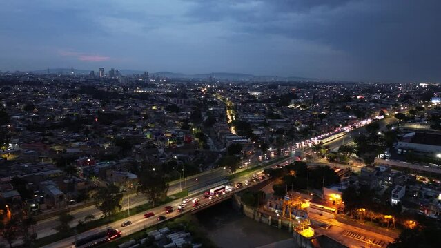 cuidad en la noche con el cielo nublado con lluvia en Guadalajara jalisco M&eacute;xico en perif&eacute;rico cargado de trafico autos en movimiento