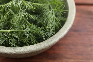Bowl of fresh dill on table, closeup. Space for text