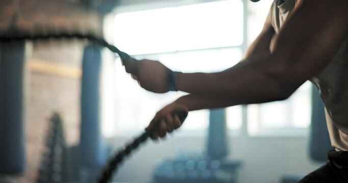 Gym, battle rope and man with exercise, hands and fitness with endurance, workout and wellness. African person, athlete and bodybuilder with training and power with health, energy and challenge