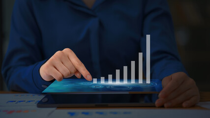 Close-up of businesswoman's hand working on a tablet computer with digital layer business strategy.