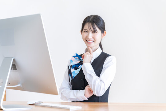 パソコンの前で考える制服を着た日本人女性