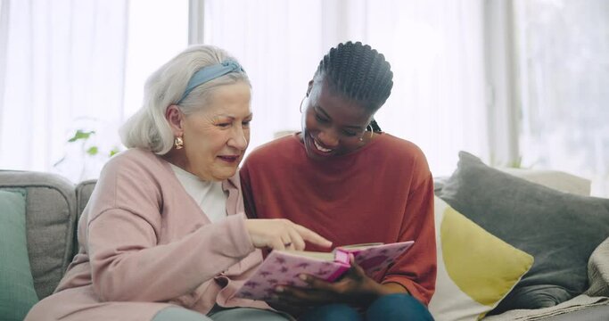 Assisted living, photo album or memory with a senior and black woman caregiver on a living room sofa. Smile, funny and elderly resident looking at a picture book with a volunteer in a retirement home