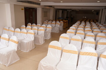 beautiful chairs arranged in line  with satin ribbon in wedding event hall